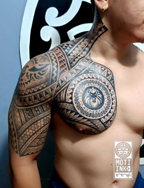 Polynesian and Filipino fusion chest and shoulder tattoo with a central lion medallion, by Miguel Lagbas / MONTI INK